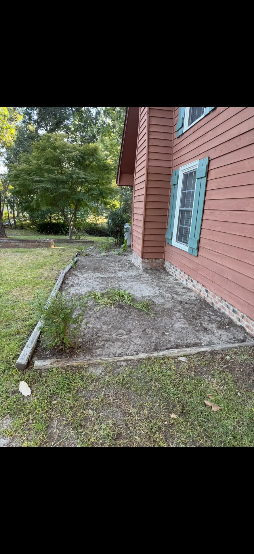 After — cleared and cleaned plant bed along the side of the same home